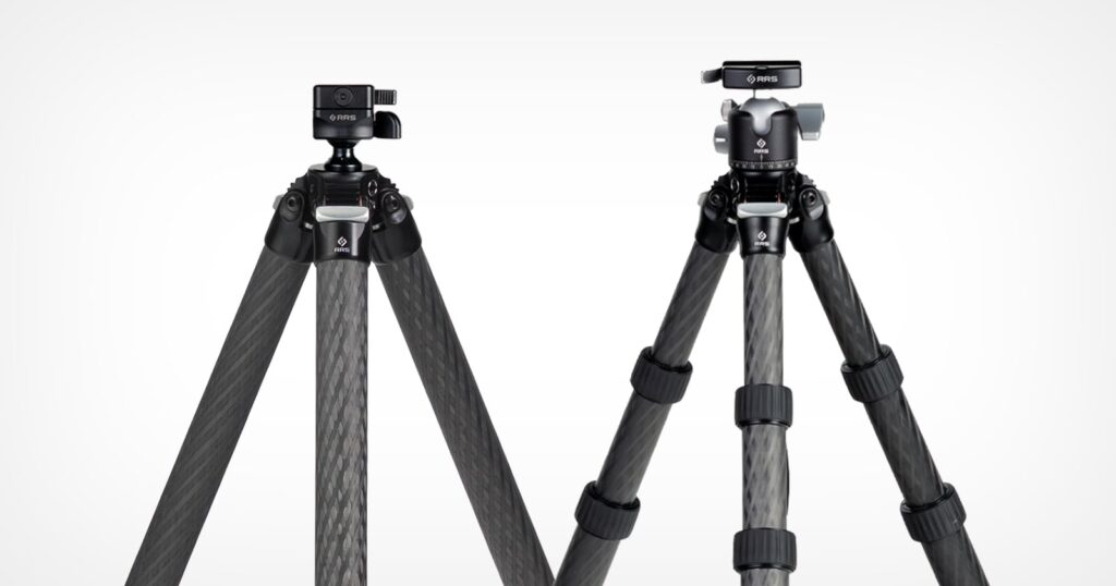 Two carbon fiber tripods with black legs are shown standing side by side against a white background. Each has a different style of tripod head mounted on top.