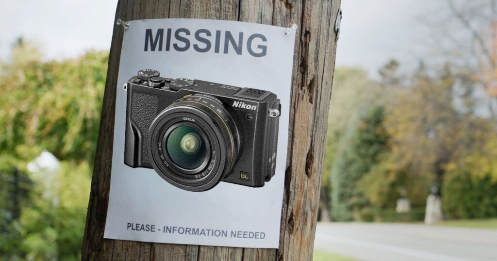 A "missing" poster on a wooden pole features a photo of a Nikon camera, requesting information. The background shows a road and green trees.