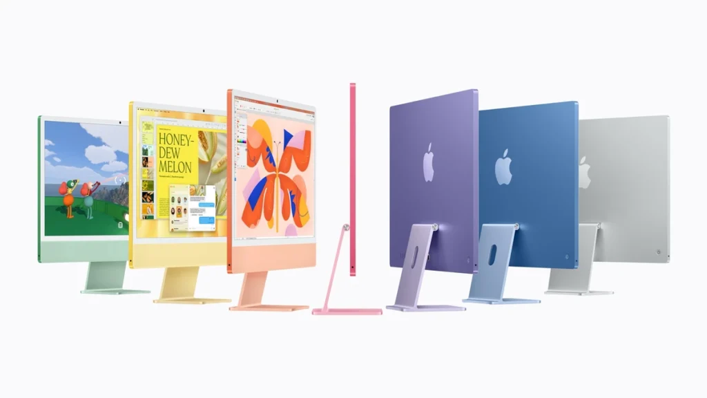 Row of colorful Apple iMac computers in green, yellow, orange, pink, purple, blue, and silver on a white background