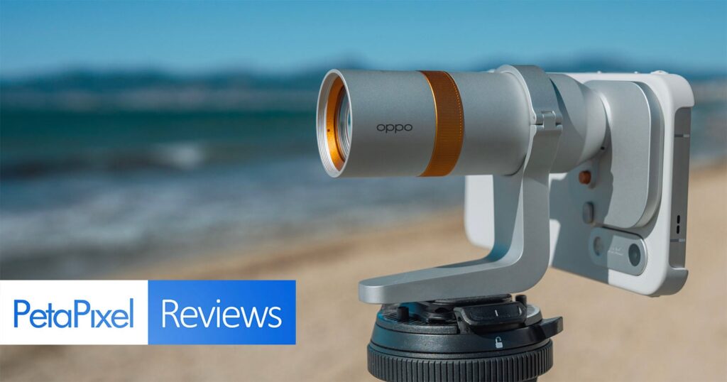 Oppo Find X10 Pro Max Review: The Incredible Triple 200MP Cameras Are Only Half the Story A silver Oppo-branded camera lens attachment mounted to a smartphone on a tripod, with a beach and ocean in the background.