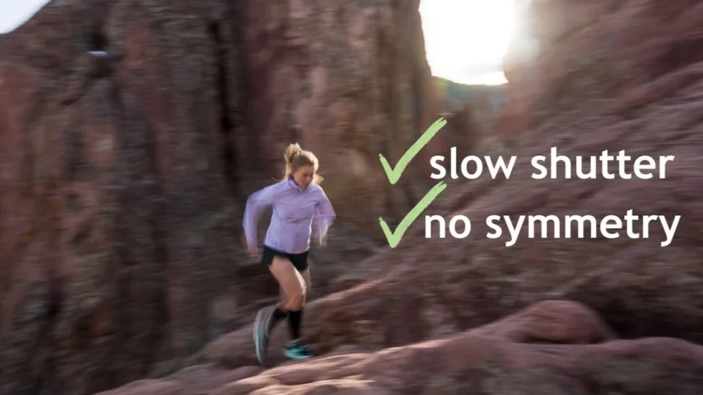 Woman trail running up red sandstone rock with motion blur, with overlaid text reading 'slow shutter' and 'no symmetry' beside checkmarks.