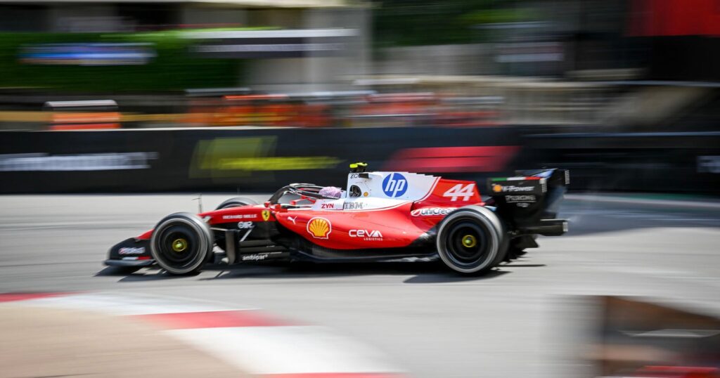 A red and white Formula 1 race car with the number 44 and HP branding drives at high speed on a track.